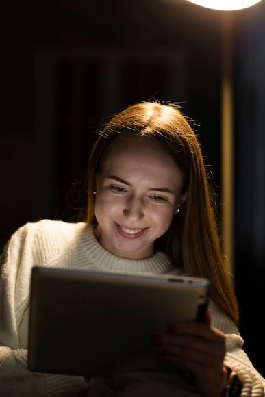 A young woman using a tablet at night, focused on local SEO and AI search optimization strategies.