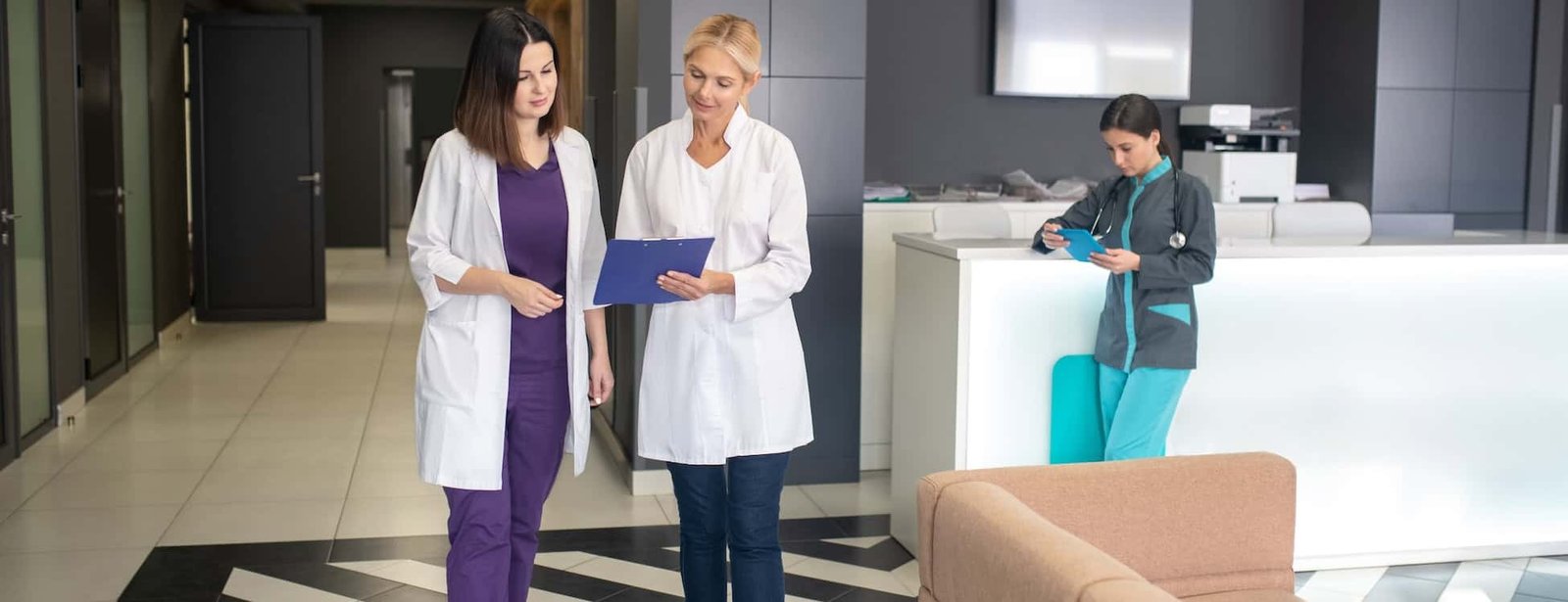 medical team discussing patient care in hospital lobby, healthcare professionals using tablets and charts, modern medical facility emphasizing health services, medical staff collaboration, healthcare and hospital SEO keywords