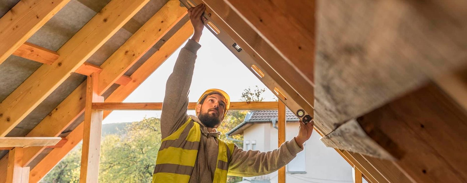 Efficient worker installing roof insulation with wood framing for a sustainable building project, emphasizing local SEO and AI search optimization for construction and building services.