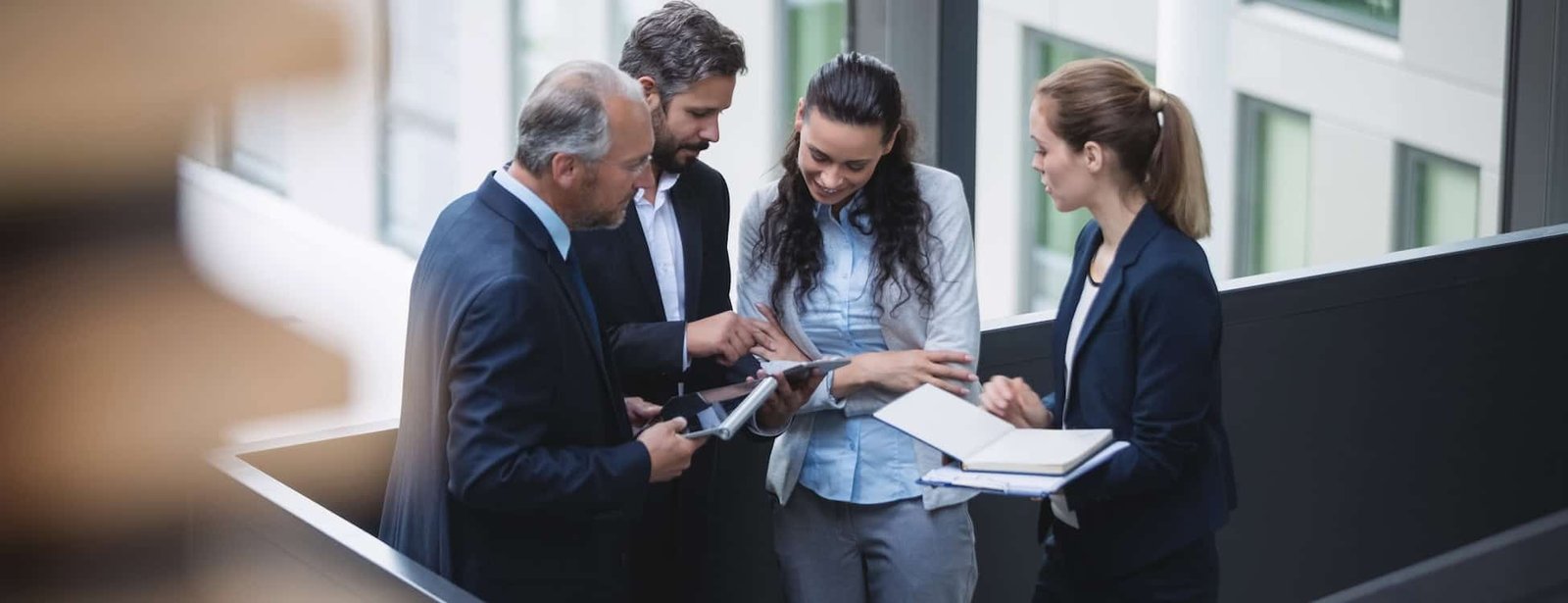 Team of business professionals collaborating and discussing strategies in a modern office setting, focusing on local SEO and AI search optimization services.
