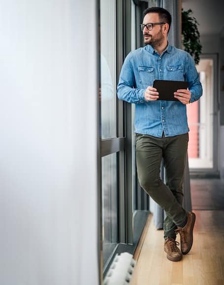 Optimized local SEO strategist analyzing AI search data with digital tablet in modern office setting, focusing on local SEO optimization and AI search optimization strategies for better online visibility.