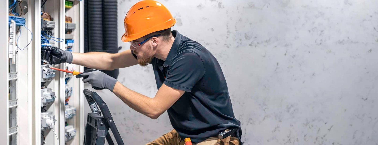 Skilled electrician repairing an industrial electrical panel, with Droved’s local SEO and AI search optimization helping electrical companies get discovered on Google Maps and AI platforms to win more local clients.