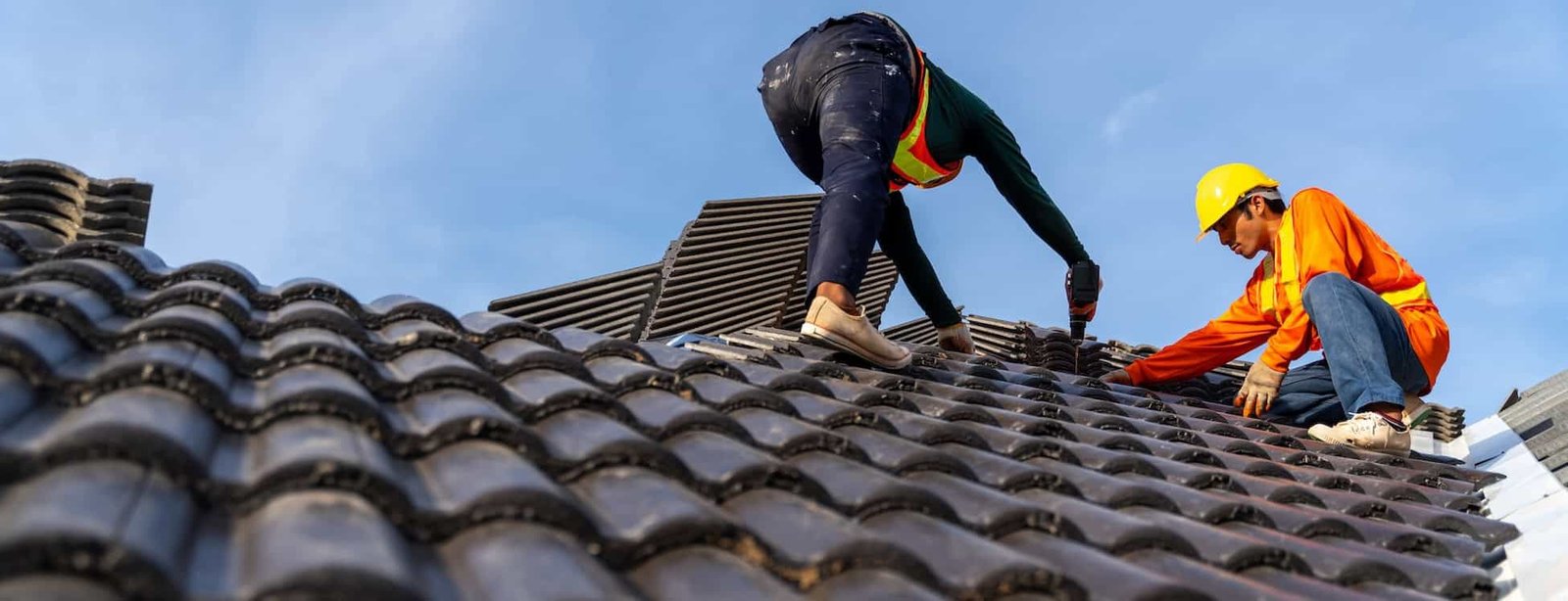 Roof repair workers installing tiles with safety gear, with Droved’s local SEO and AI search optimization helping roofing companies appear on Google Maps and AI platforms to attract more clients.